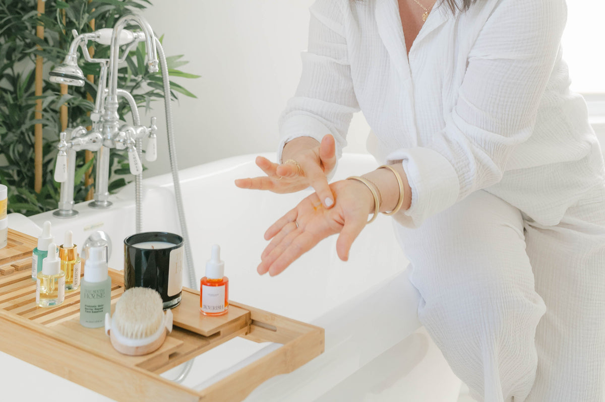 Sixth House products on a bath shelf with Jennie using a product